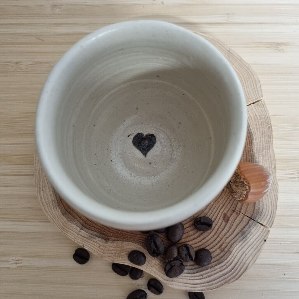 Tasse en céramique avec finitions texturées et décoration gravée à la main.